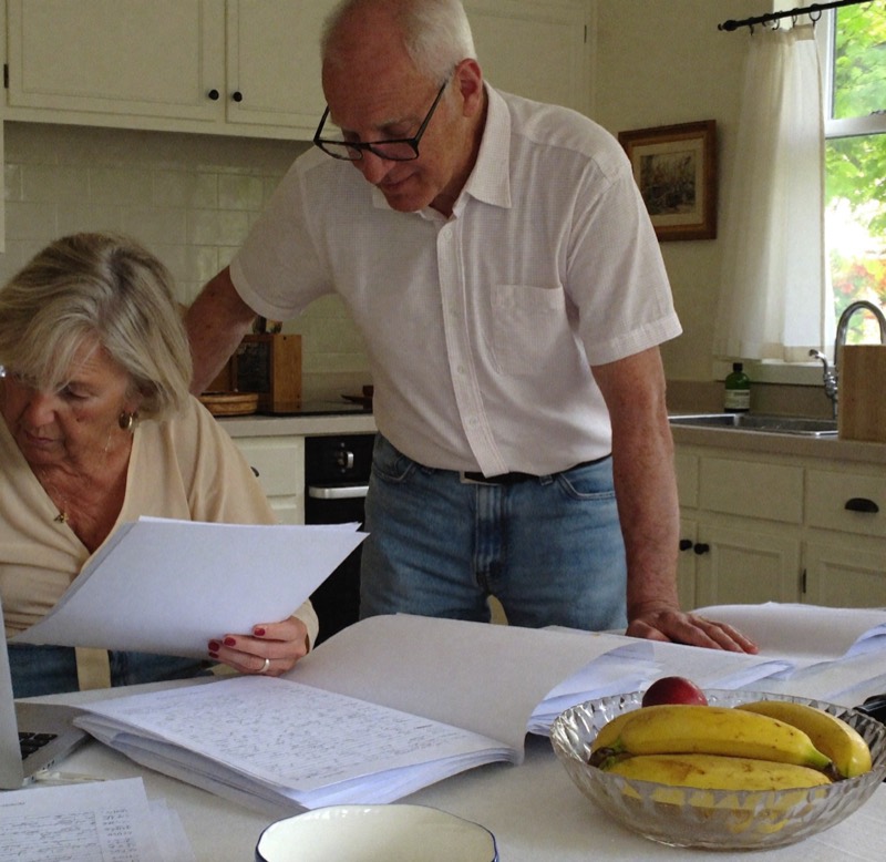 A couple at their kitchen table reading through solar paperwork