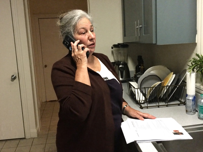 A homeowner on the phone in her kitchen with her paperwork
